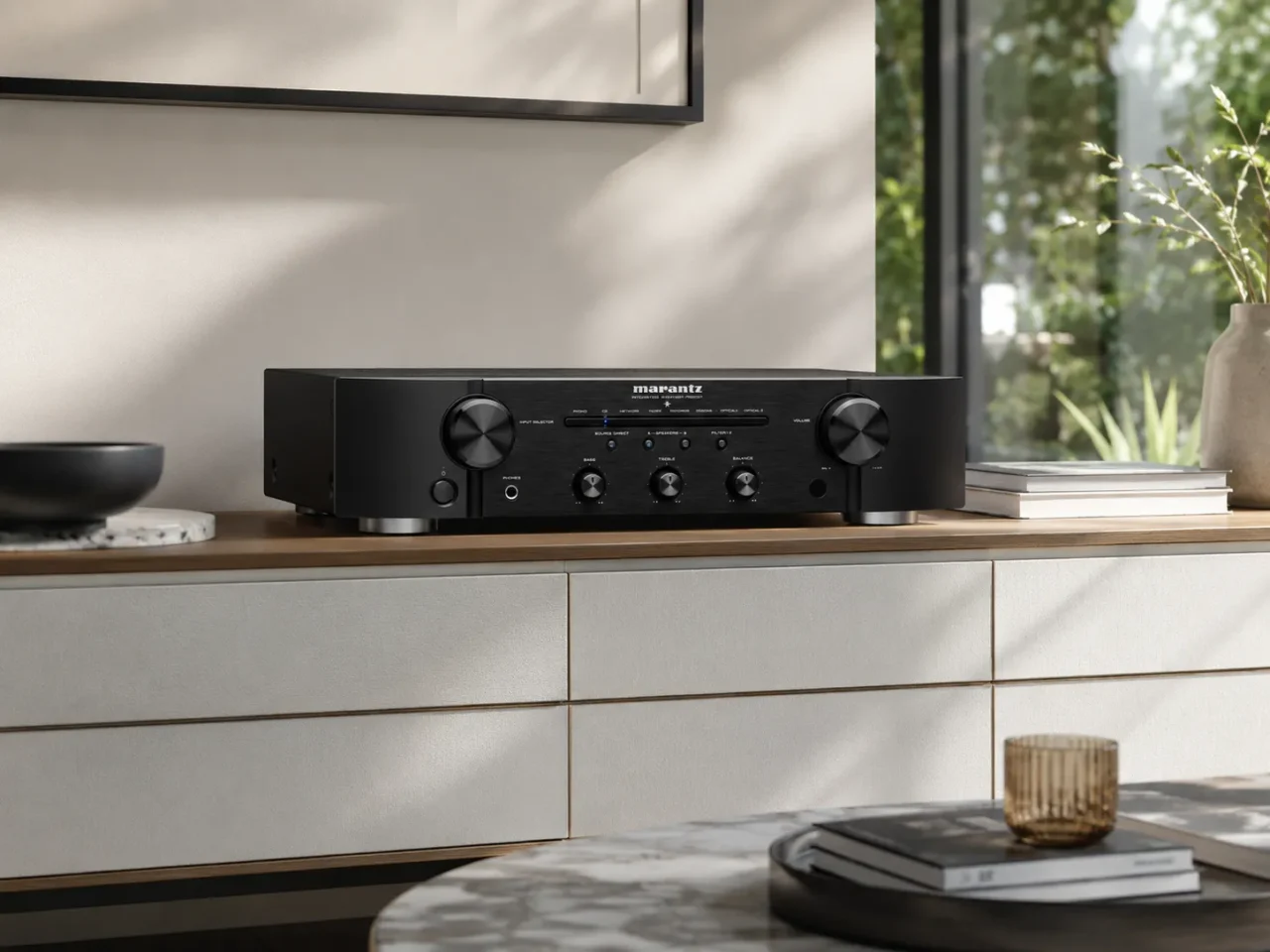 Amplificador integrado Marantz PM6007 color negro con panel frontal oscuro y dial de volumen iluminado en rack de audio Hi-Fi.